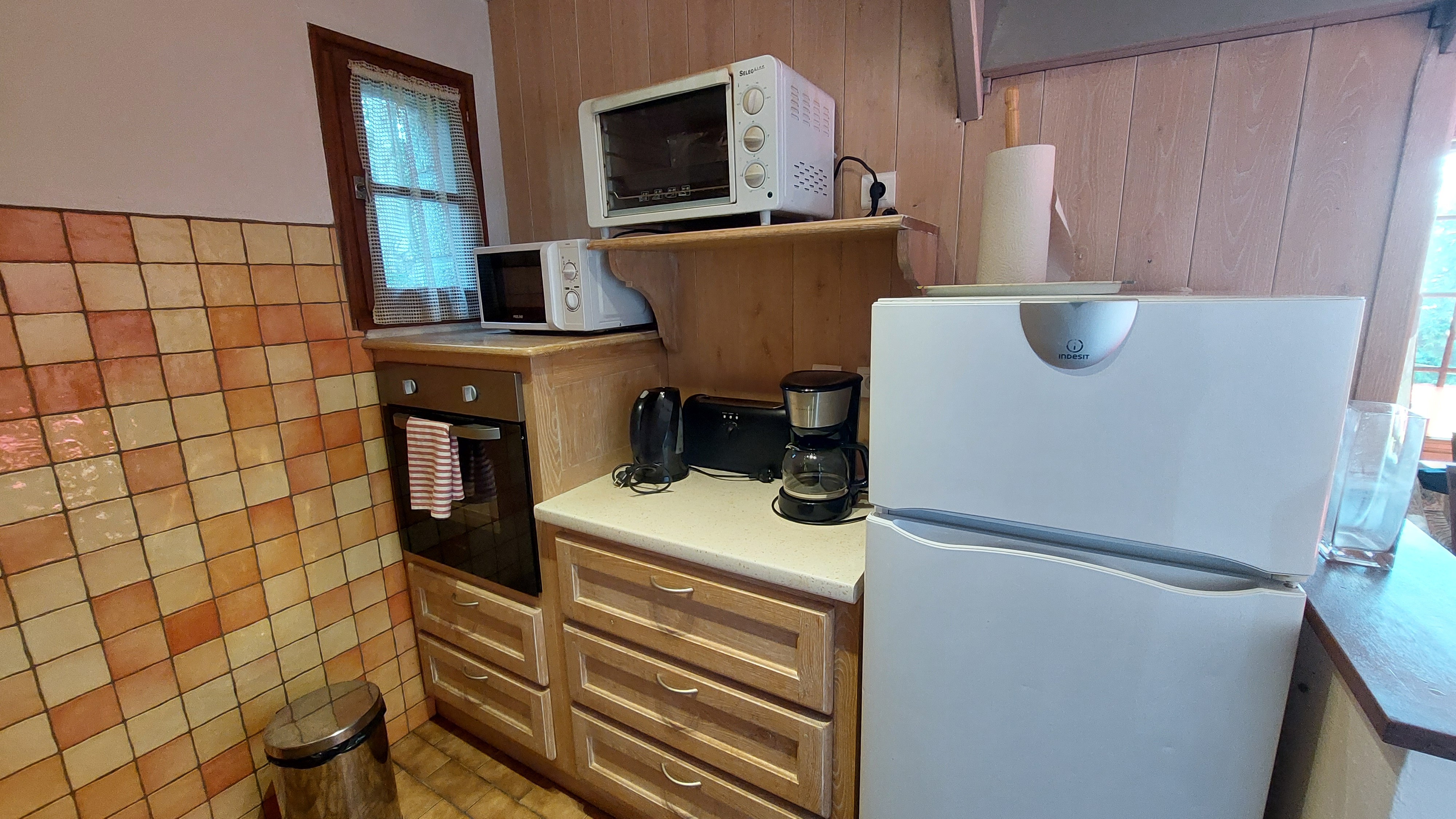 Vue sur la cuisine rustique, entièrement aménagée pour un séjour confortable.