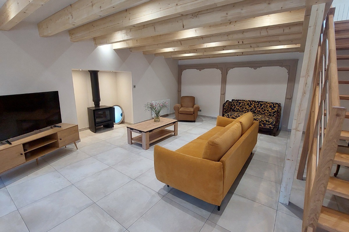 Salon avec TV et poêle à bois