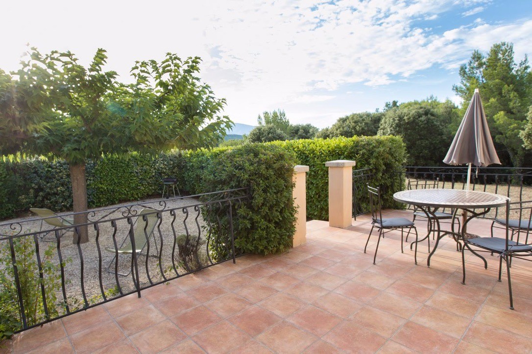 Terrasse et cour privatives ombragées, équipées de mobilier de jardin et d'un barbecue