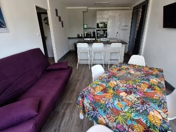 Pièce de vie avec cuisine équipée, salon et coin repas du gîte Lilas
