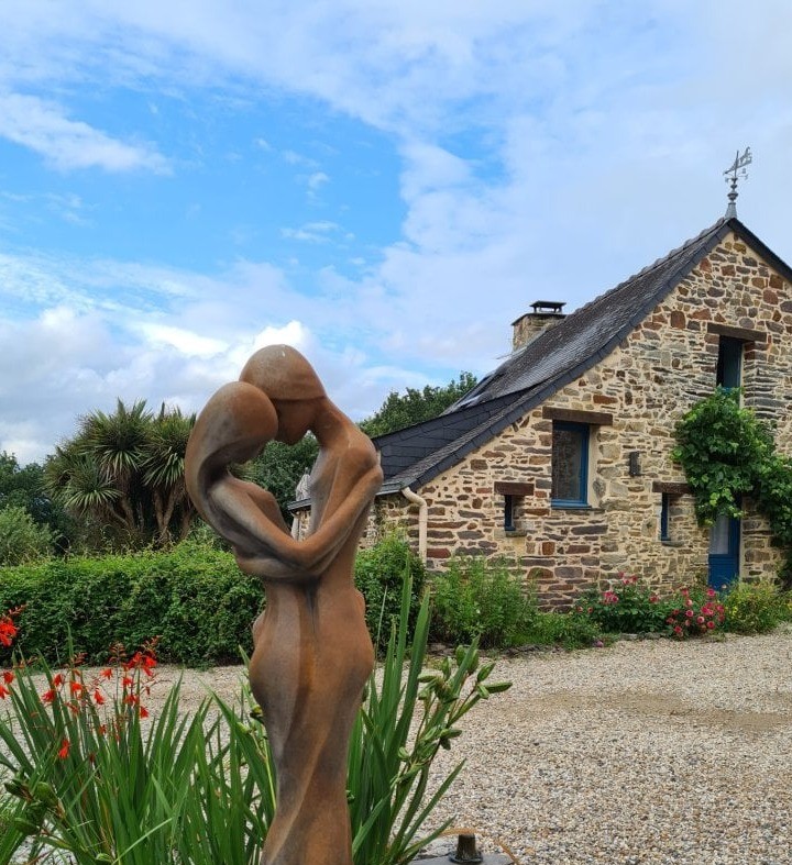 Sculpture sur le domaine, avec en arrière plan le gîte du Val