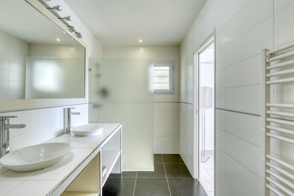 Salle de bain avec chauffe-serviettes et coin douche
