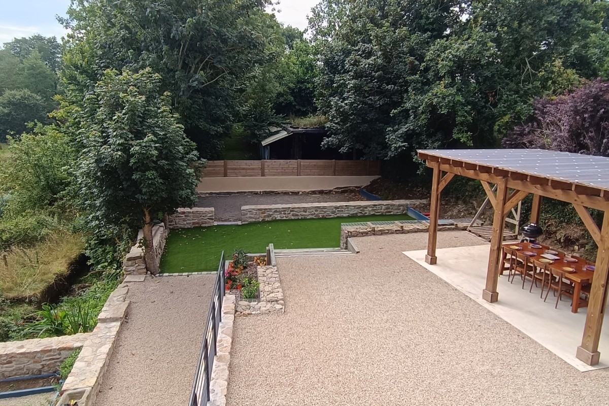 Les espaces extéreurs de la location avec la pergola et le terrain de pétanque