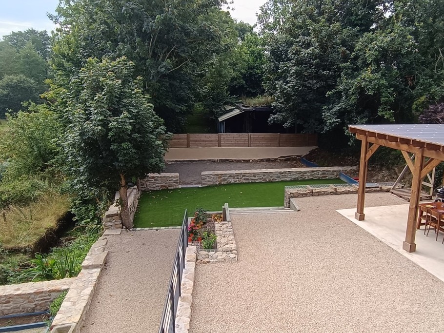 Les espaces extéreurs de la location avec la pergola et le terrain de pétanque