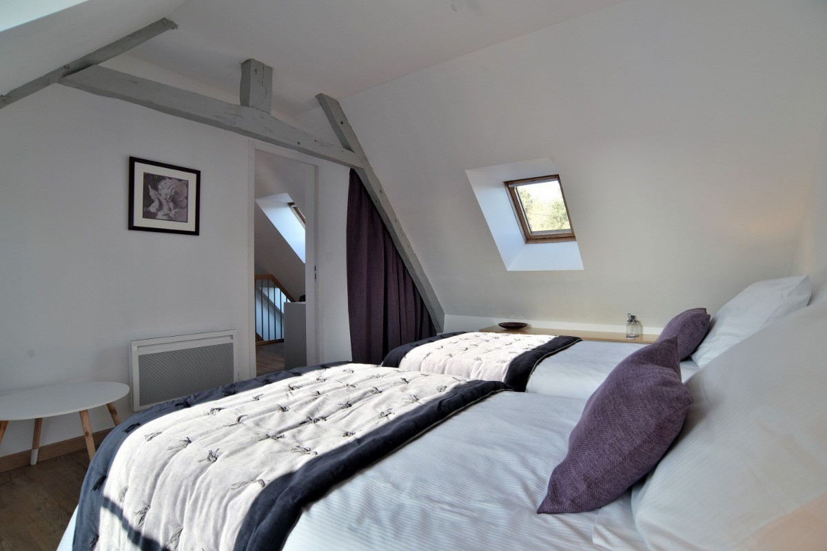 1 chambre mansardée pour 2 personnes au 2nd étage (avec deux lits individuels très confort 100x200 cm). Salle d'eau, WC séparés et coin bureau au même étage.