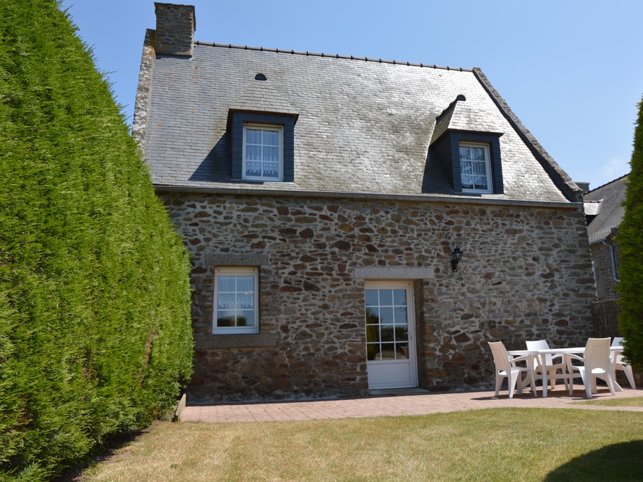 Agréable jardin de 600 m² avec terrasse et salon de jardin, transats, et barbecue.
