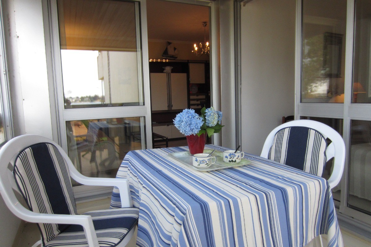 Loggia couverte avec salon de jardin et accès au séjour et à la chambre