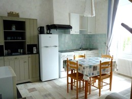 Pièce de vie en RDC avec coin cuisine bien équipée et coin salon avec TV.