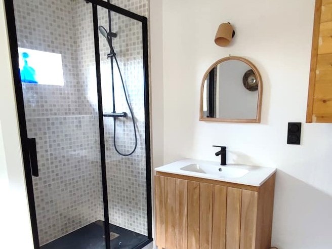 Grand salon chaleureux avec poutres apparentes et cheminée d'apparat.
Crédits photo : Mégane ARNAL