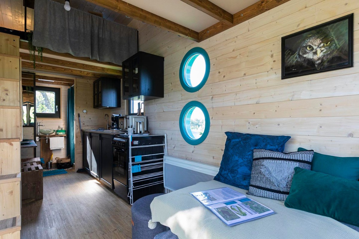 Partie salon et cuisine et jeux de sociétés divers à l'intérieur de notre pouf - Tiny House O Ptit Nid Milie