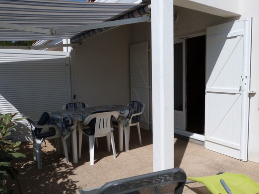 Terrasse avec salon de jardin, store-banne et bains de soleil