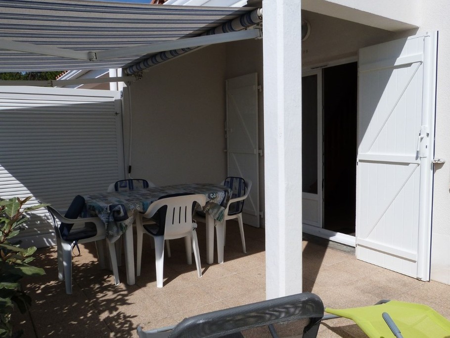 Terrasse avec salon de jardin, store-banne et bains de soleil