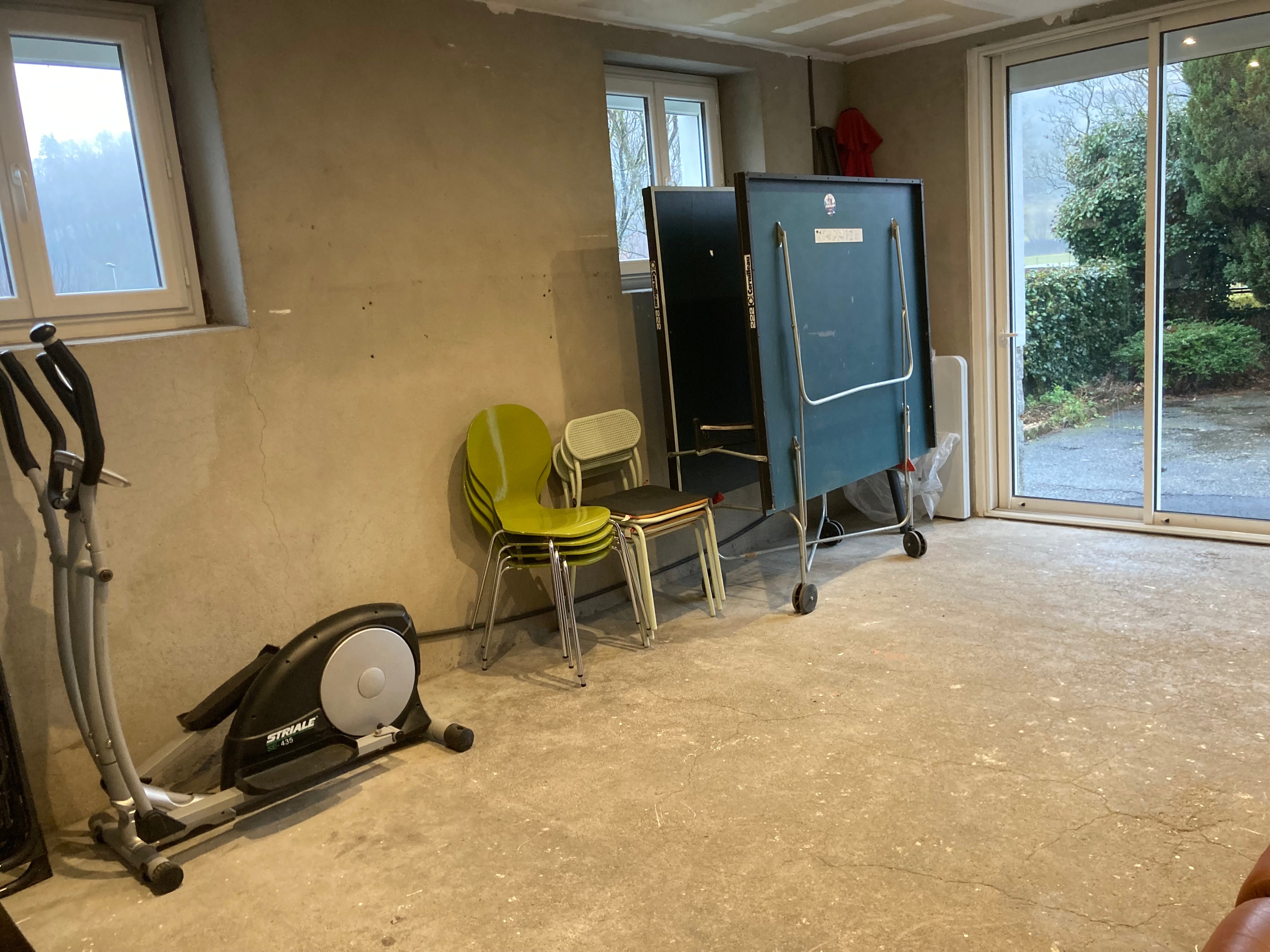 salle de jeu local  pour vélos, skis, clubs de golf, matériel de pêche...table et canapé, vélo d'intérieur,  table de ping pong
