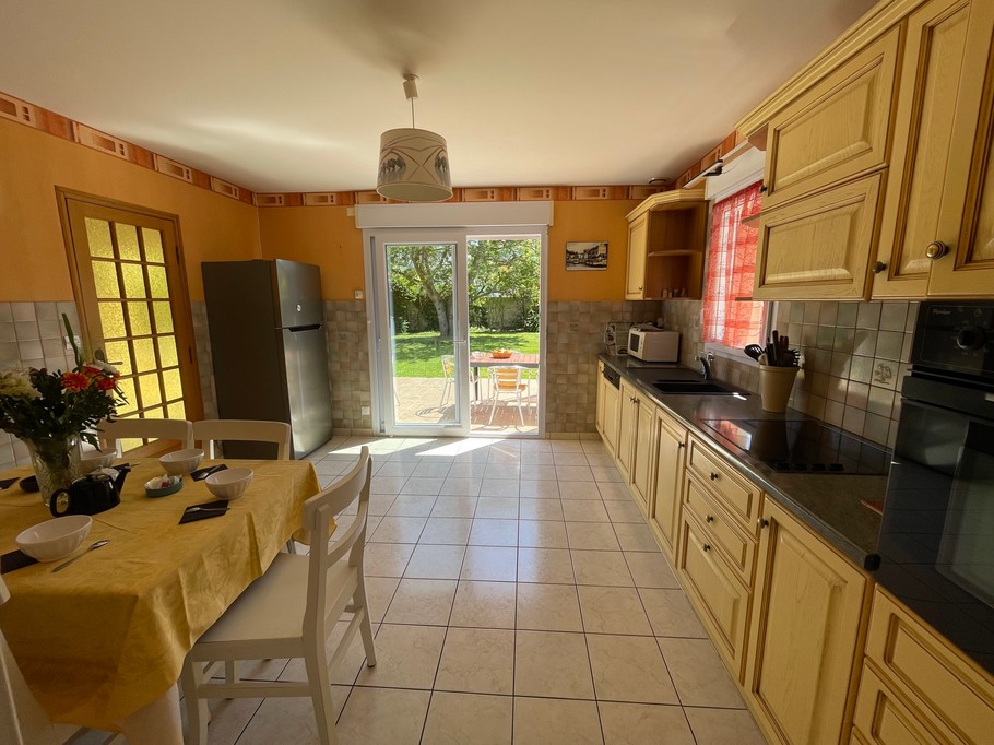 La cuisine avec coin repas communique avec le séjour et la terrasse