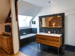 Chambre 1 : chambre spacieuse pour deux personnes avec lit 160x200 cm, TV, canapé, et sa grande salle de bain double vasques (baignoire et douche) et WC séparés.