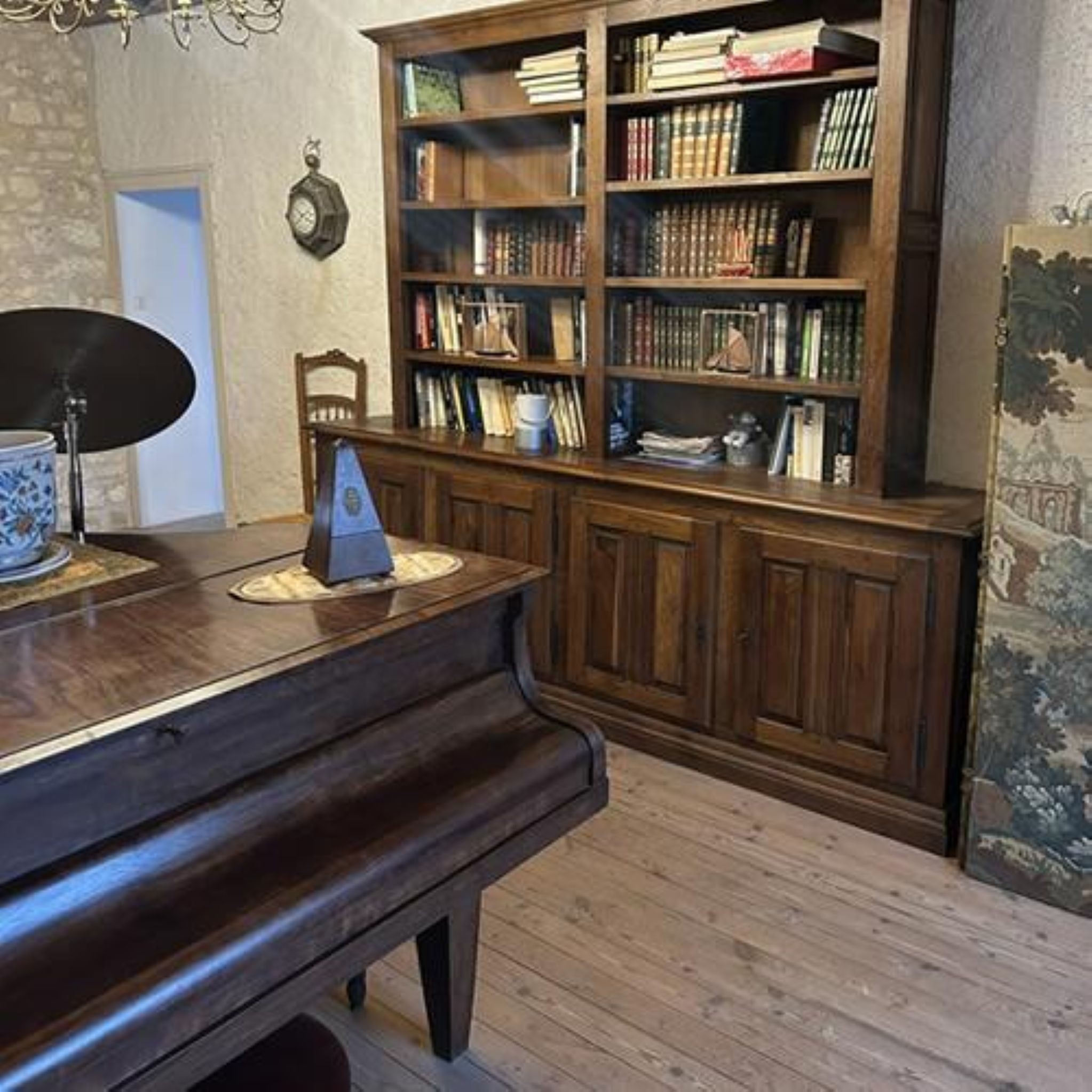 La Maison Gareshé, au 1er étage, sur le palier avec un piano familial et la bibliothèque