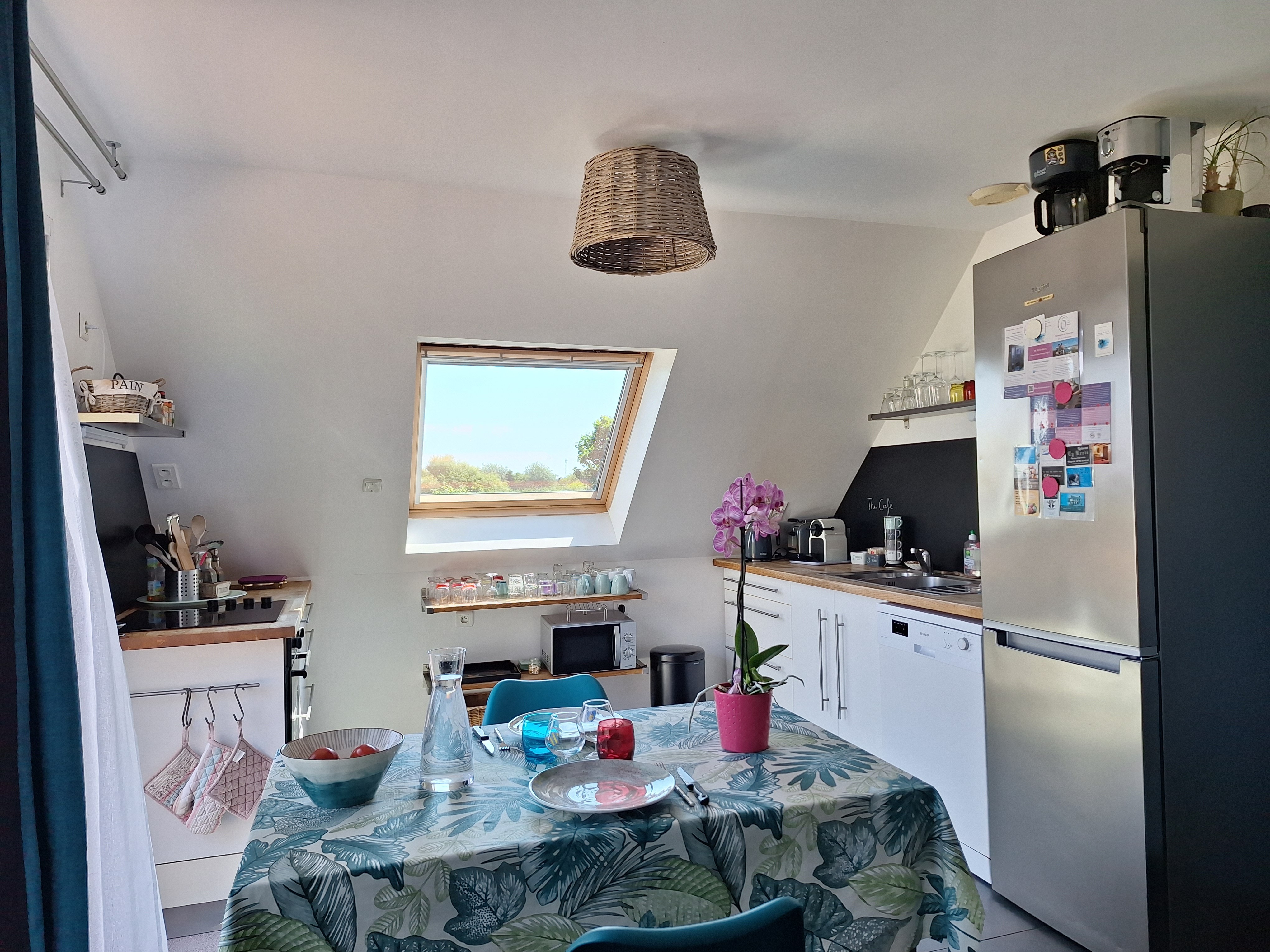 Cuisine équipée : plaque induction 4 feux, four électrique, four micro-onde, lave vaisselle, réfrigérateur avec compartiment congélation.