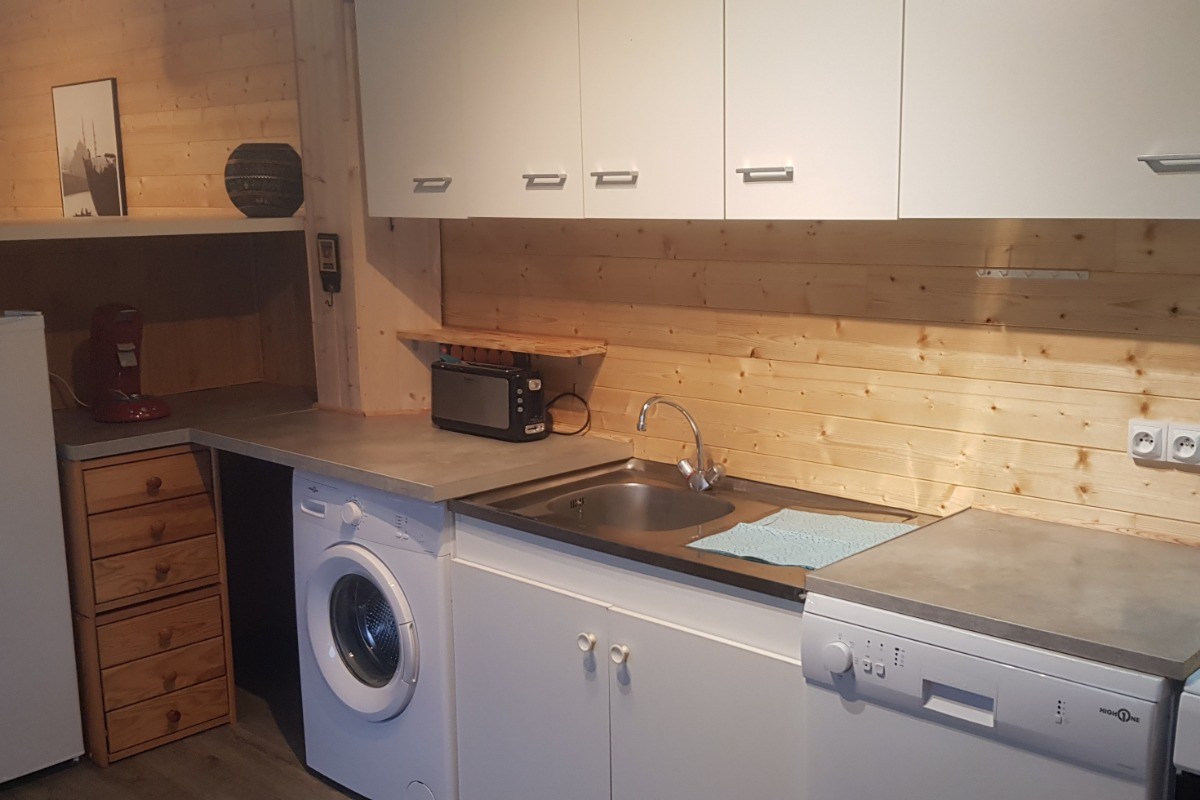 Cuisine équipée communicante avec la terrasse couverte et la pièce de vie.