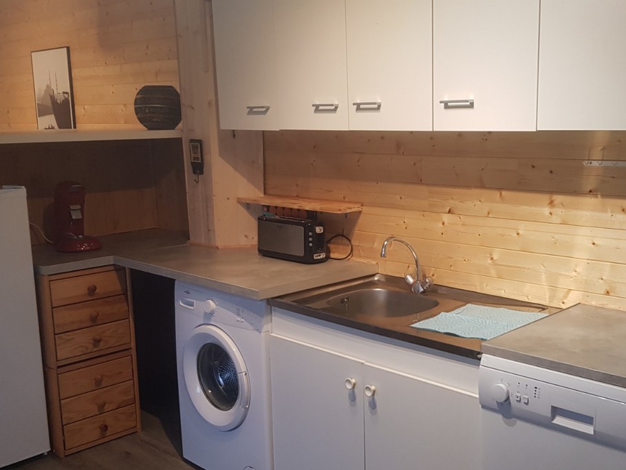 Cuisine équipée communicante avec la terrasse couverte et la pièce de vie.