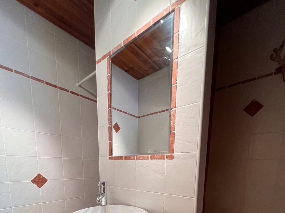 Salle d'eau attenante à la chambre 1, équipée d'un WC, d'un lavabo et d'une douche.