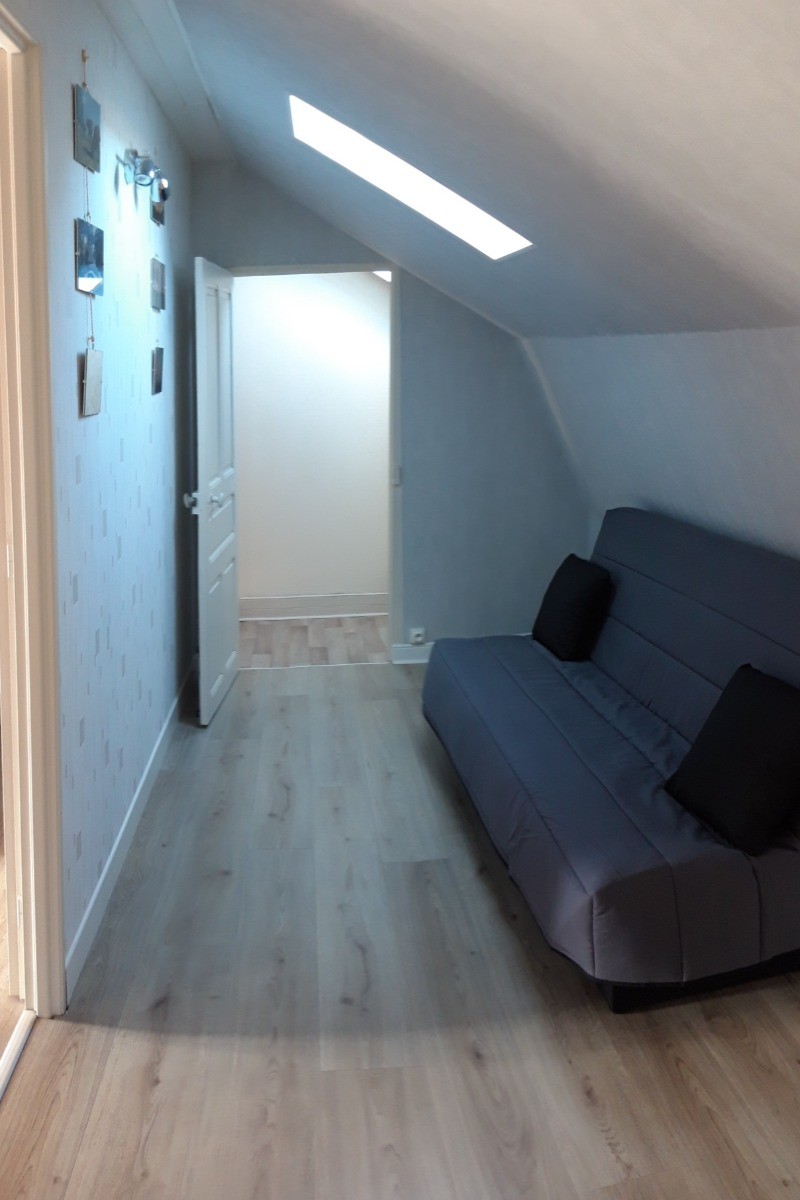 "Couloir aménagé avec un canapé convertible, offrant un couchage d'appoint pratique