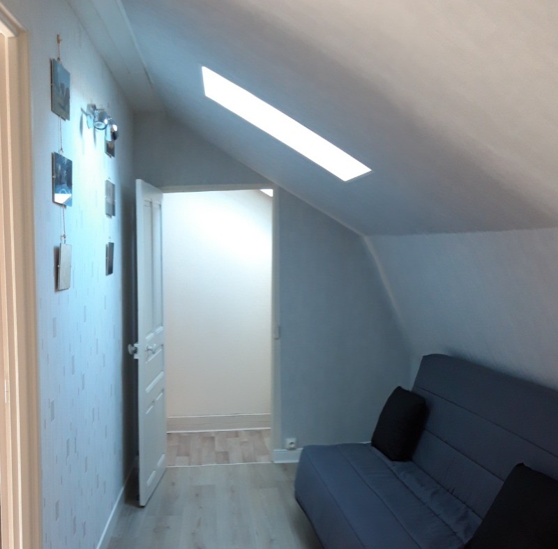 "Couloir aménagé avec un canapé convertible, offrant un couchage d'appoint pratique