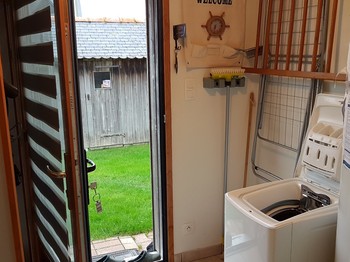 Pièce Buanderie avec machine à laver. 
Crédits photo : Clévacances 35