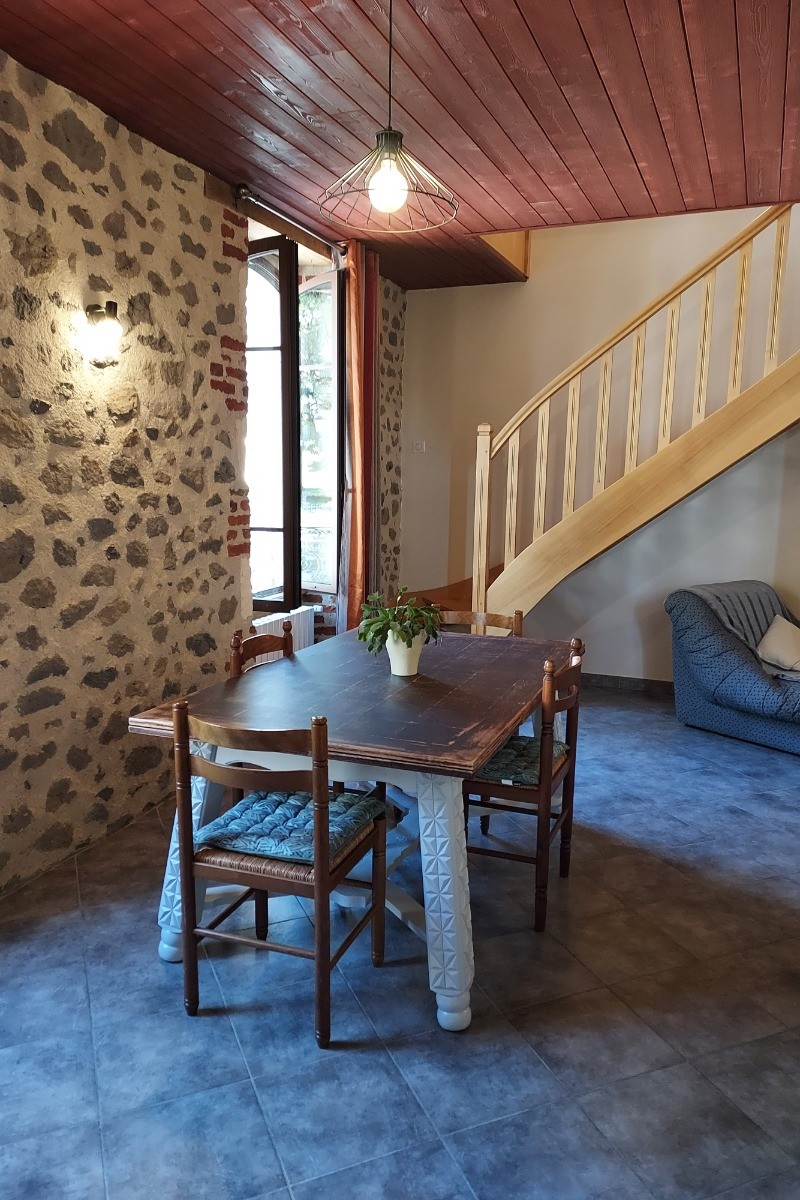 le coin repas avec l'escalier qui monte à l'étage.