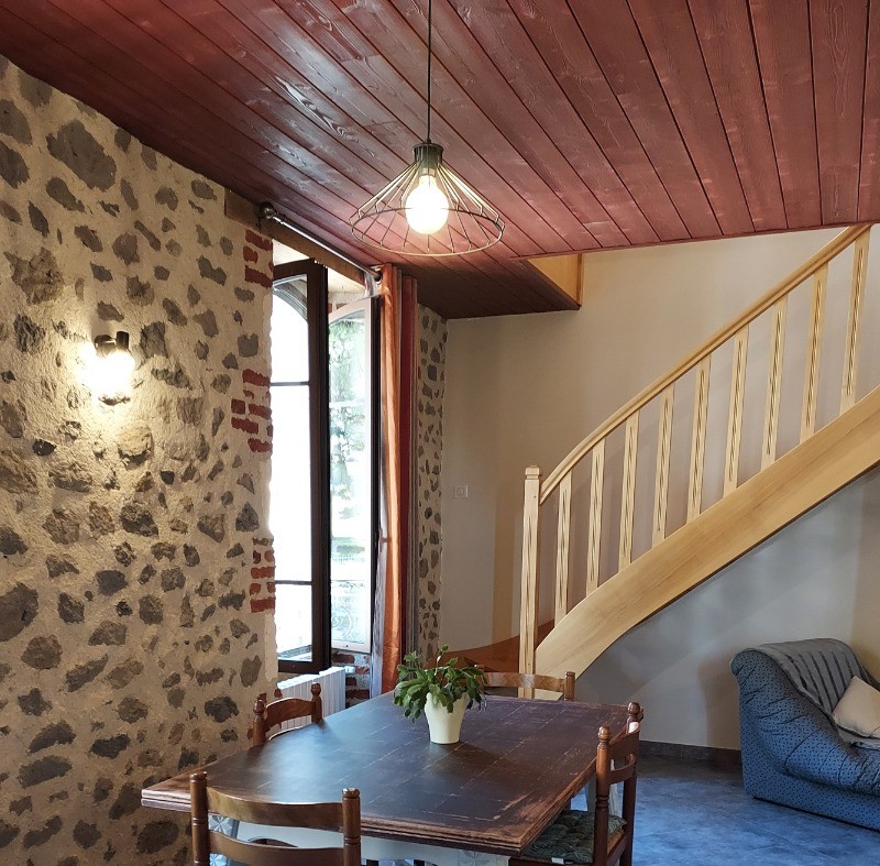 le coin repas avec l'escalier qui monte à l'étage.