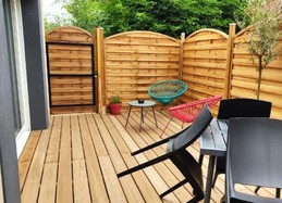 Terrasse en bois accessible par un portillon ou par la baie vitrée. Abris clos et sécurisé pour vos vélos et autre petit matériel. Grill électrique à votre disposition.