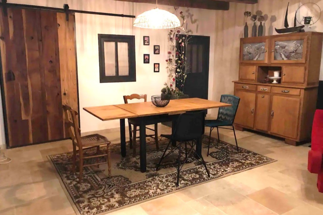 Grande pièce de vie rénovée en respectant l'âme du lieu, et meublée avec du mobilier finement chiné.