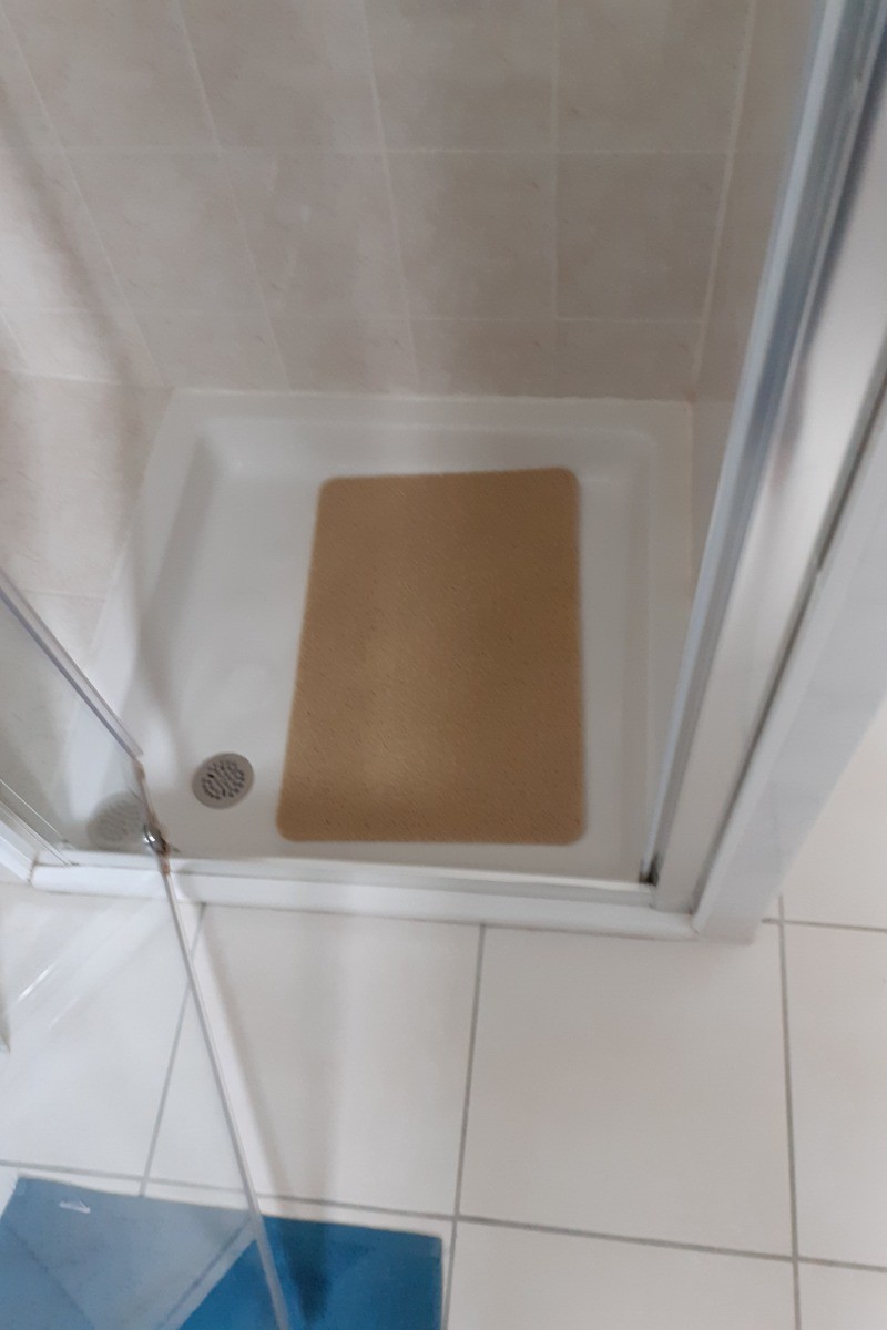 Salle d'eau avec lavabo, douche, radiateur sèche-serviette.