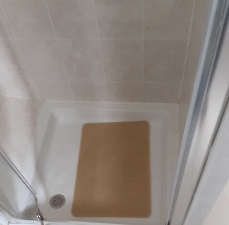 Salle d'eau avec lavabo, douche, radiateur sèche-serviette.