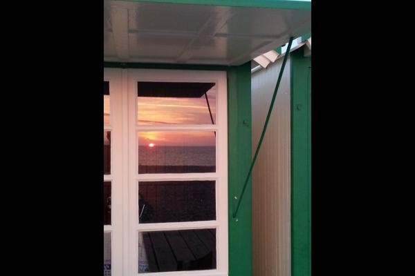 coucher de soleil vu de l'intérieur d'une cabine de plage