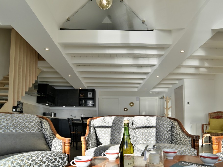 Coin salon de la pièce de vie très lumineuse vue mer panoramique. Mezzanine à l'étage avec deux couchages, conseillée pour les enfants (faible hauteur sous plafond).
Appartement au 2nd étage en front de mer au Port de la Houle à Cancale.