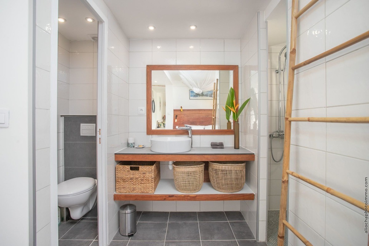 Salle d'eau avec douche à l'italienne et WC fermé.