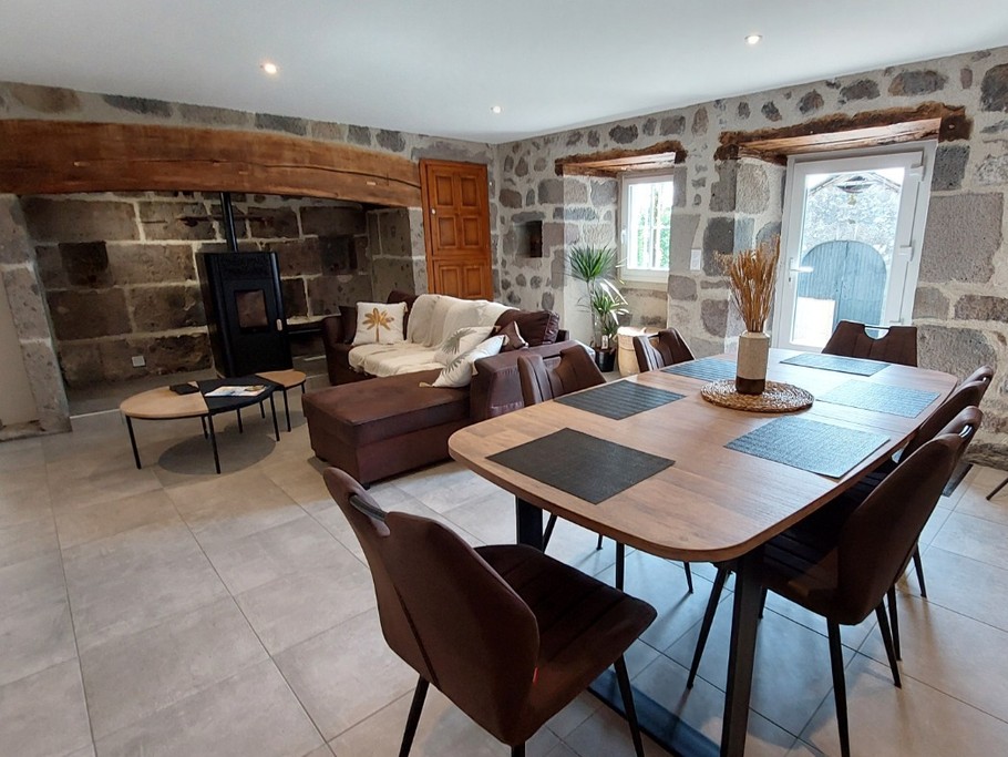 Salle à manger élégante du gîte La Petite Maison avec table scandinave en bois et chaises contemporaines.