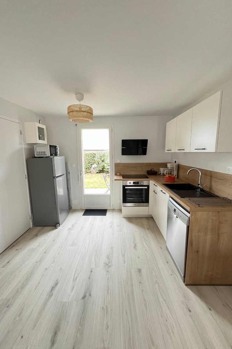 Au rez-de-chaussée, coin cuisine toute aménagée dans la grande pièce de vie contenant aussi un coin salon à l'entrée et coin séjour. Accès direct à la terrasse depuis la cuisine .