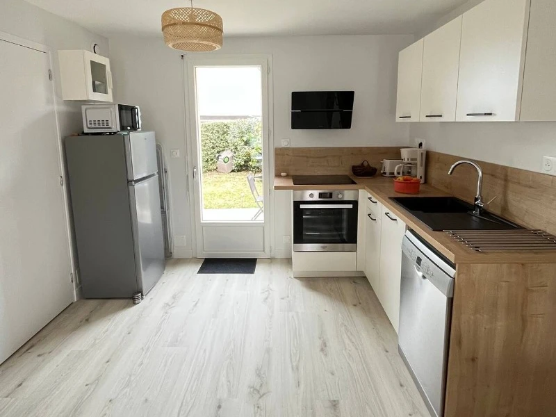 Au rez-de-chaussée, coin cuisine toute aménagée dans la grande pièce de vie contenant aussi un coin salon à l'entrée et coin séjour. Accès direct à la terrasse depuis la cuisine .