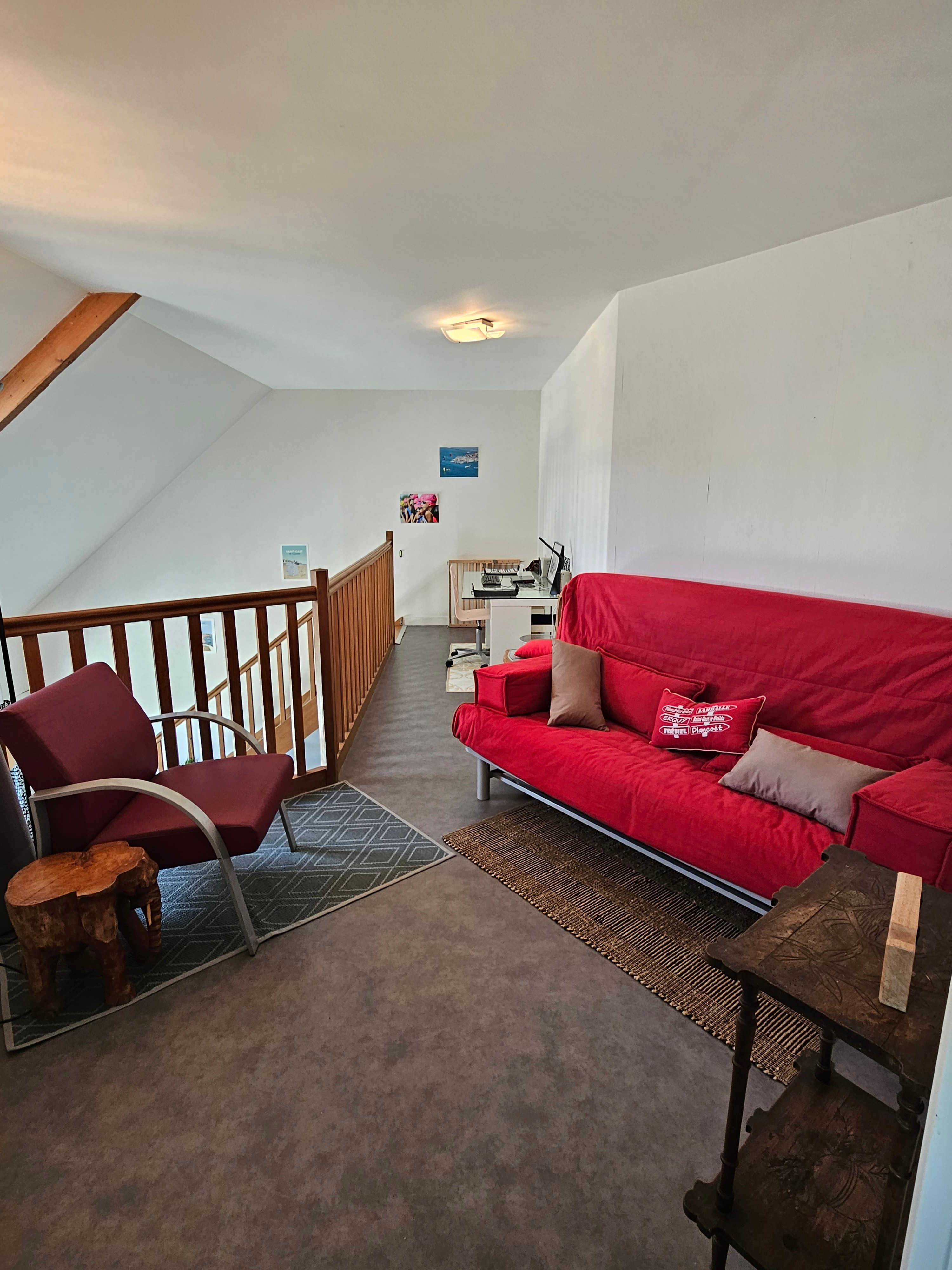 Mezzanine ouverte sur la pièce de vie, avec coin bureau et espace détente avec canapé convertible.