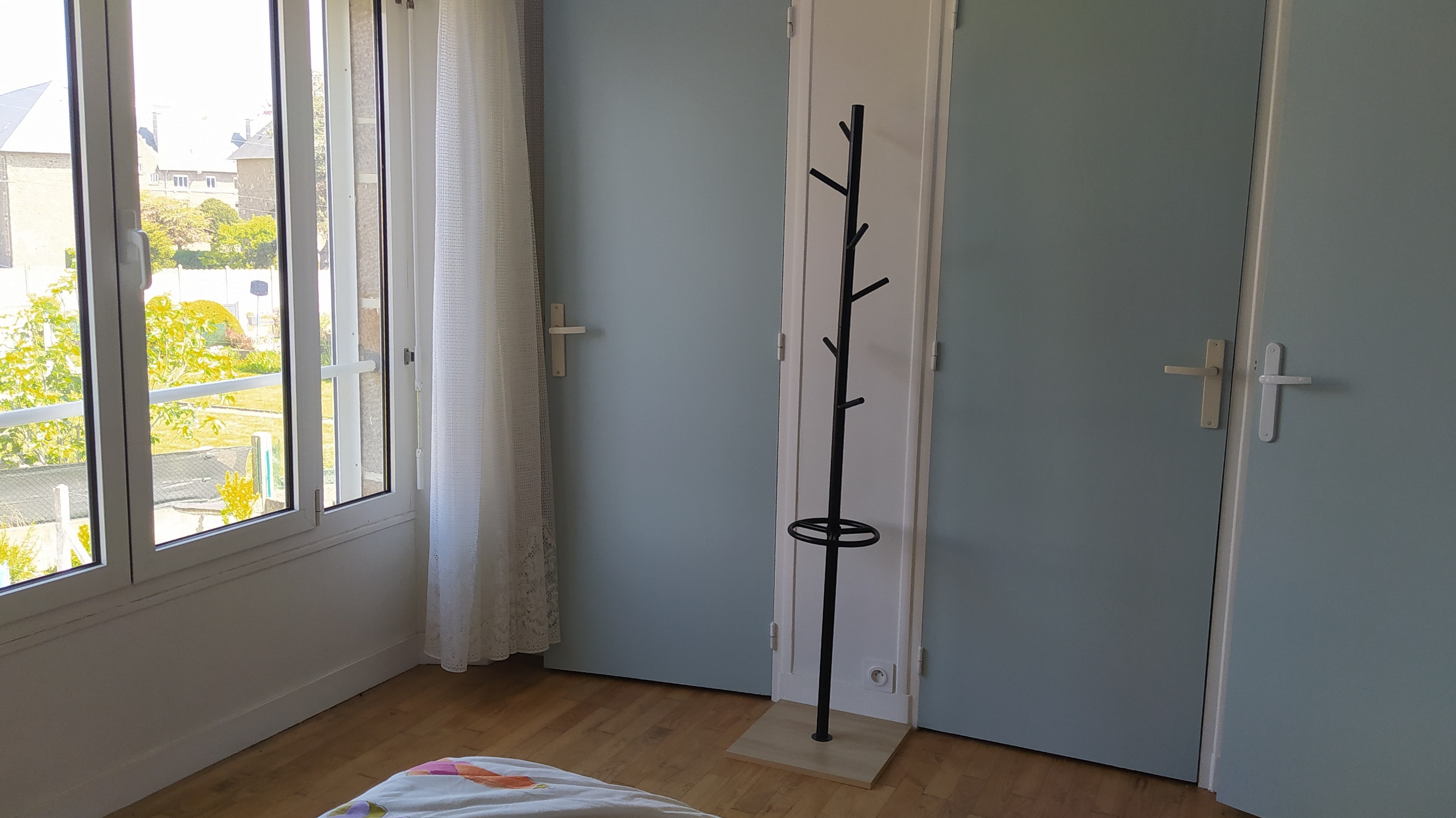 Chambre 1 avec un lit 140 cm, rangements, porte-manteau, et salle d'eau communicante (douche grande dimension et meuble vasque avec miroir)