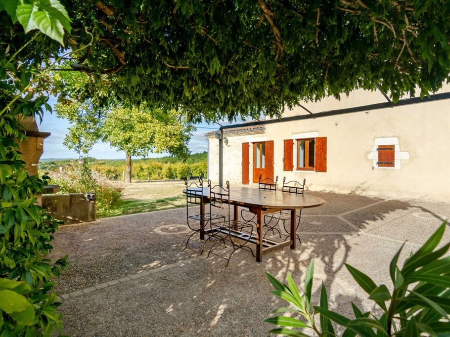 Salon de jardin sous pergola végétalisée