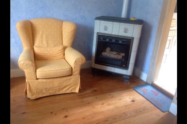 2 fauteuils avec le poêle en faïence au gaz en salle à manger