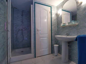 Salle d'eau avec douche et WC fermé communicante à la chambre