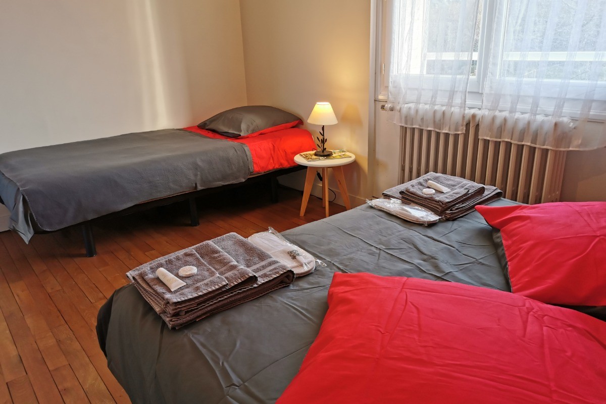 Le lit 90x140 en appoint au pied du lit 140x190 dans la chambre Coquelicot
