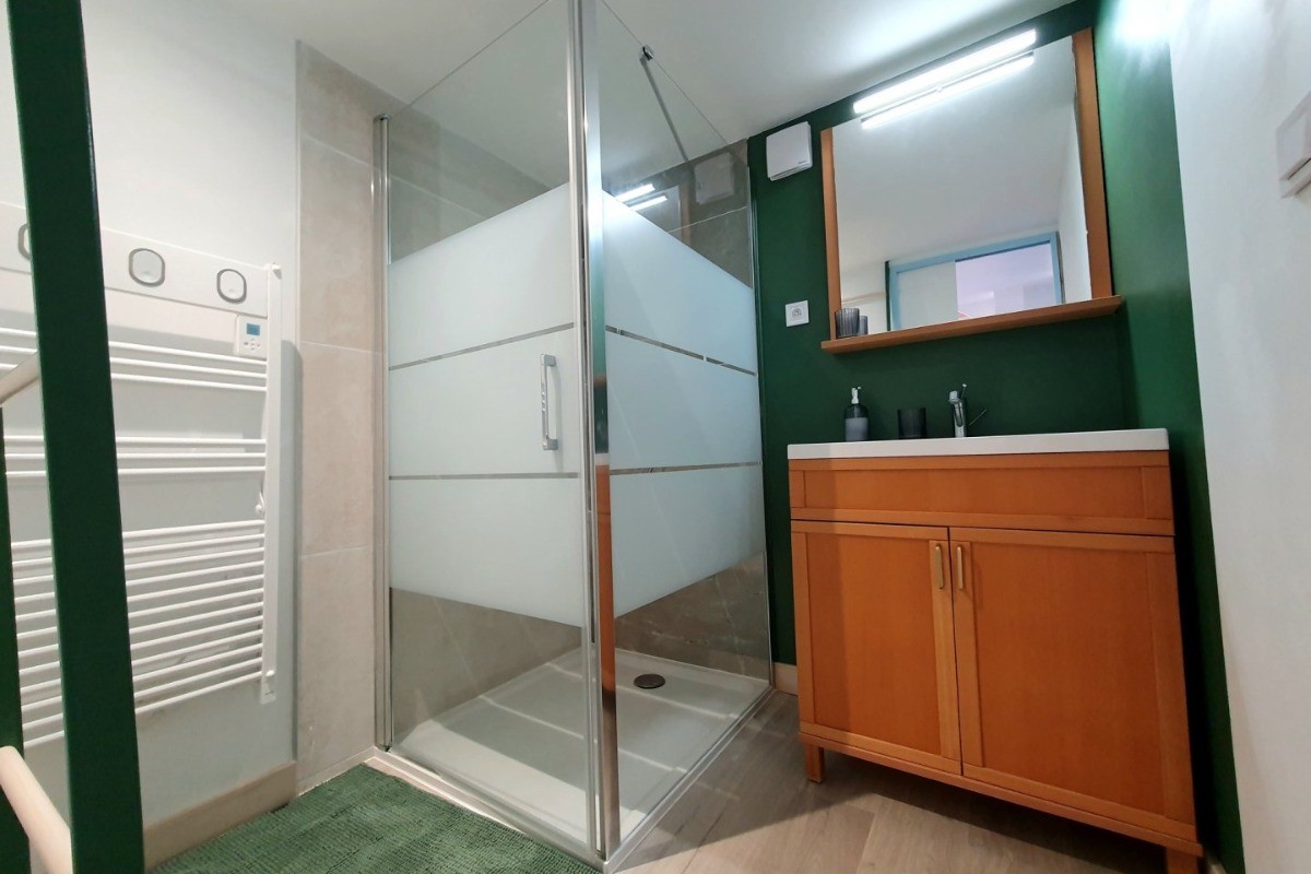 Salle d'eau avec douche grande dimension, meuble vasque et radiateur sèche serviette