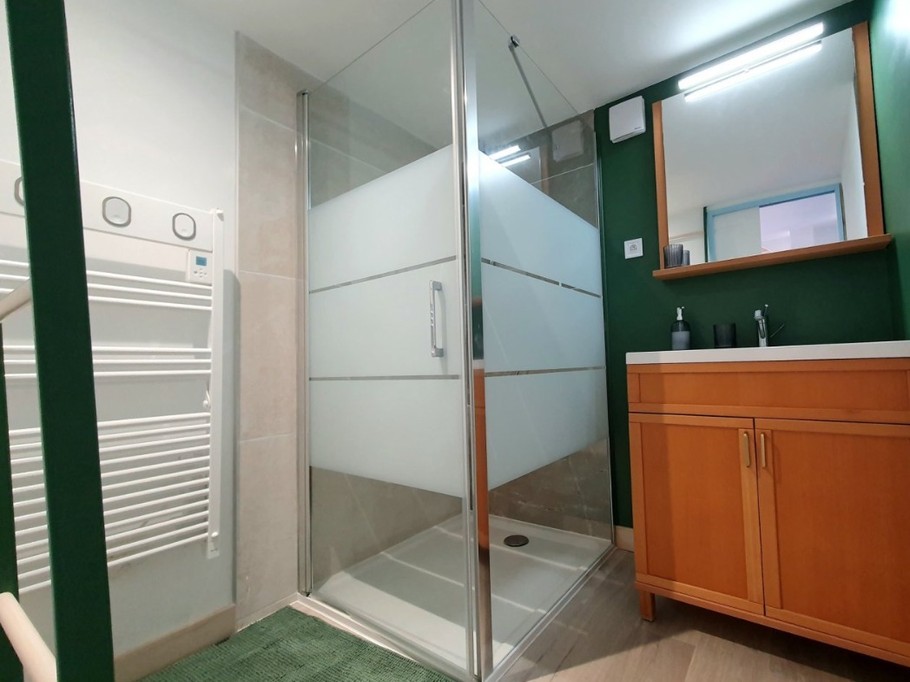 Salle d'eau avec douche grande dimension, meuble vasque et radiateur sèche serviette