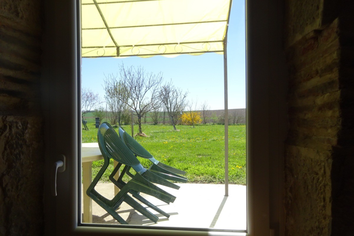 Vue sur la terrasse depuis le salon la fenêtre vous permet de passer les plats directement afin de manger sur la terrasse plus confortablement