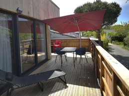 Grande terrasse de plus de 40 mètres carrés avec transats et salon de jardin.