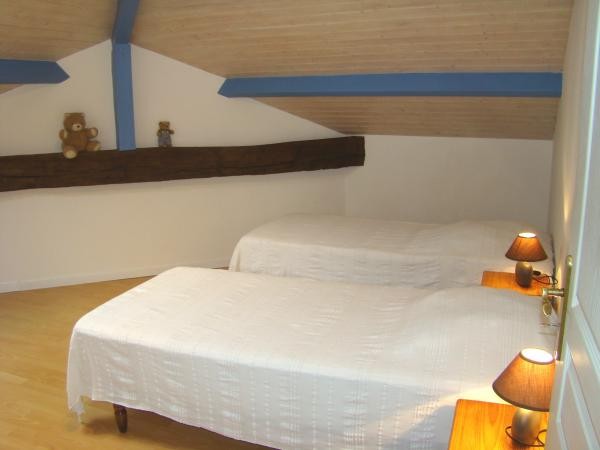 Chambre bleue climatisée avec 2 lits de 90 cm et point d'eau